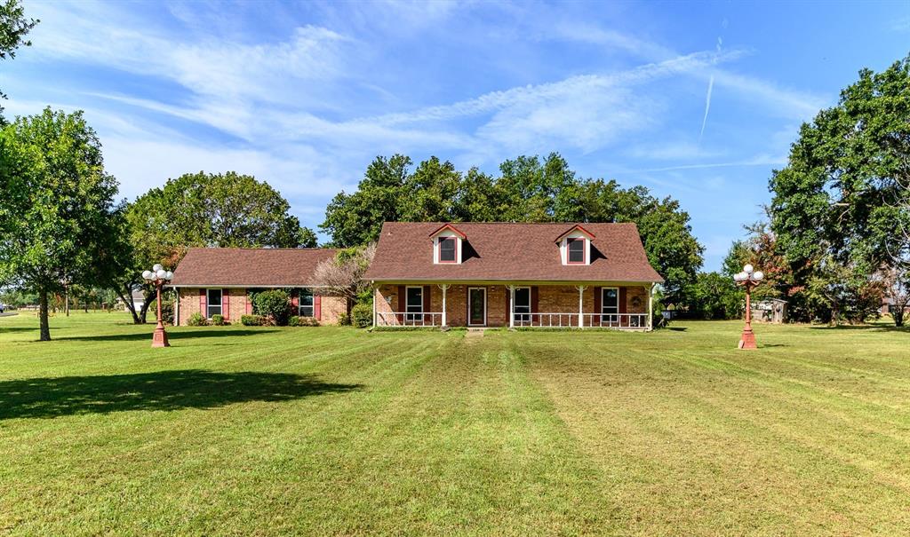 a front view of a house with a yard and trees