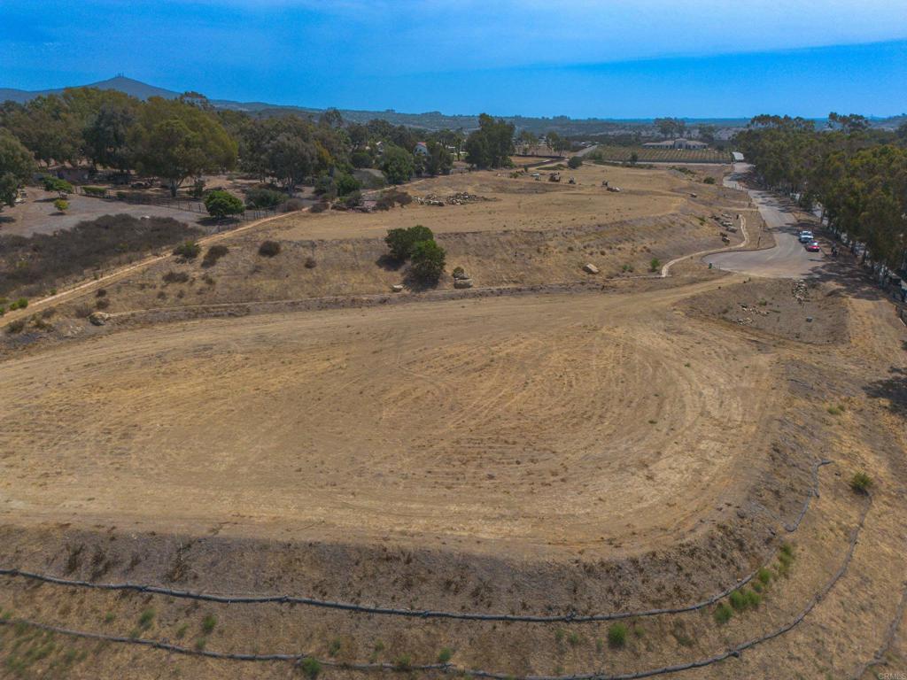 a view of dirt field with ocean view