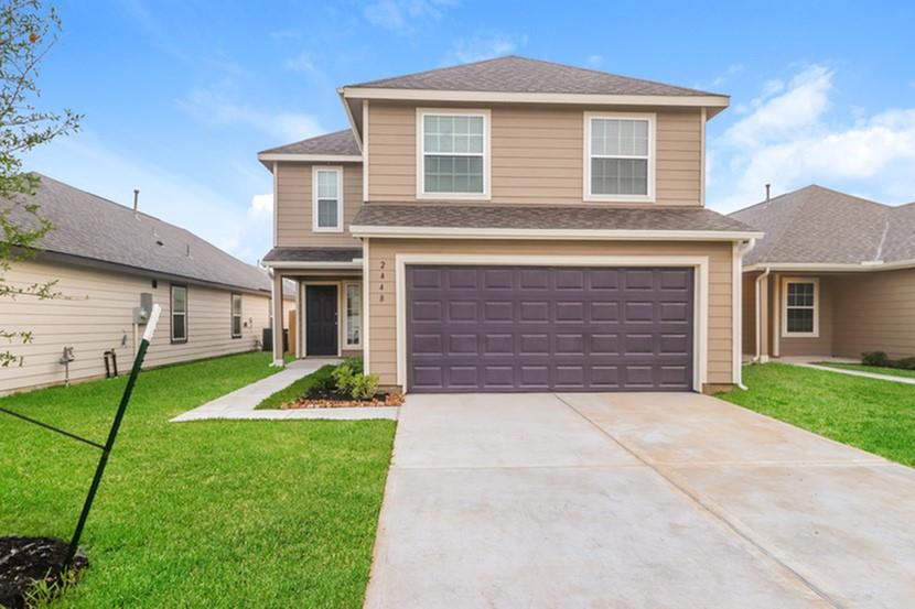 a front view of a house with a yard and garage