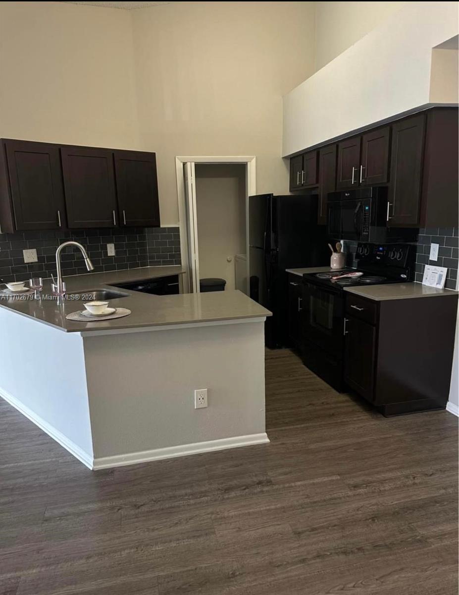 a kitchen with kitchen island granite countertop a sink cabinets and stainless steel appliances