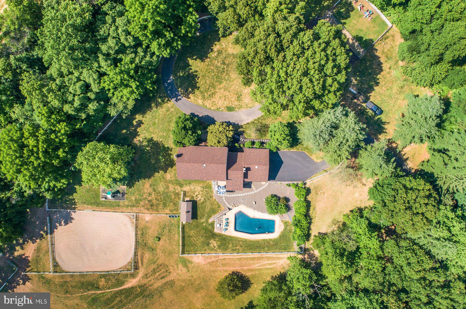 an aerial view of residential houses with outdoor space and trees all around