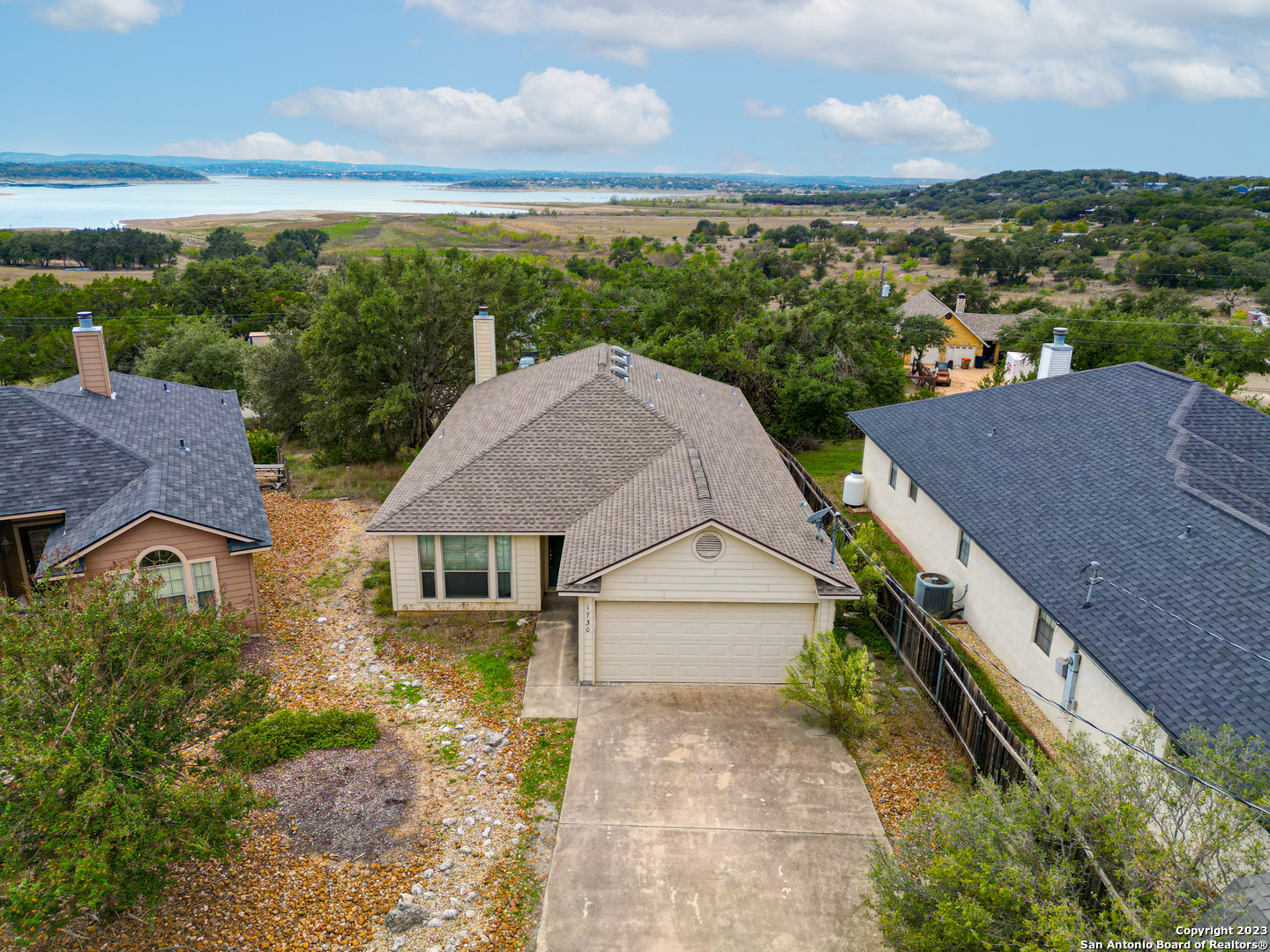 an aerial view of a house with a yard and lake view