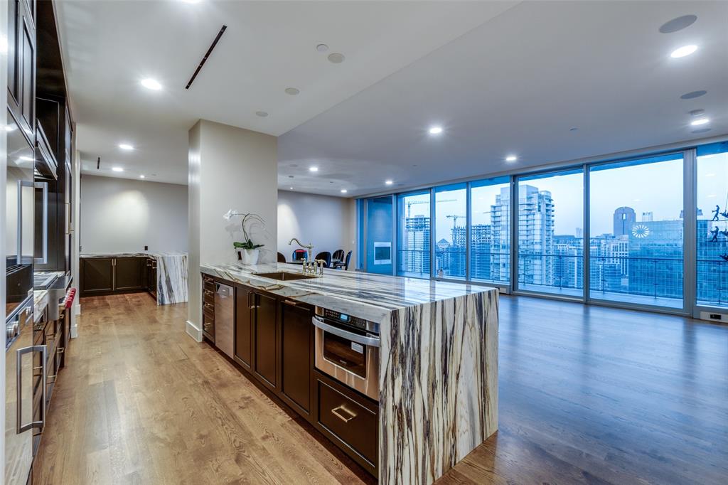 a kitchen with stainless steel appliances granite countertop a stove and a wooden floors