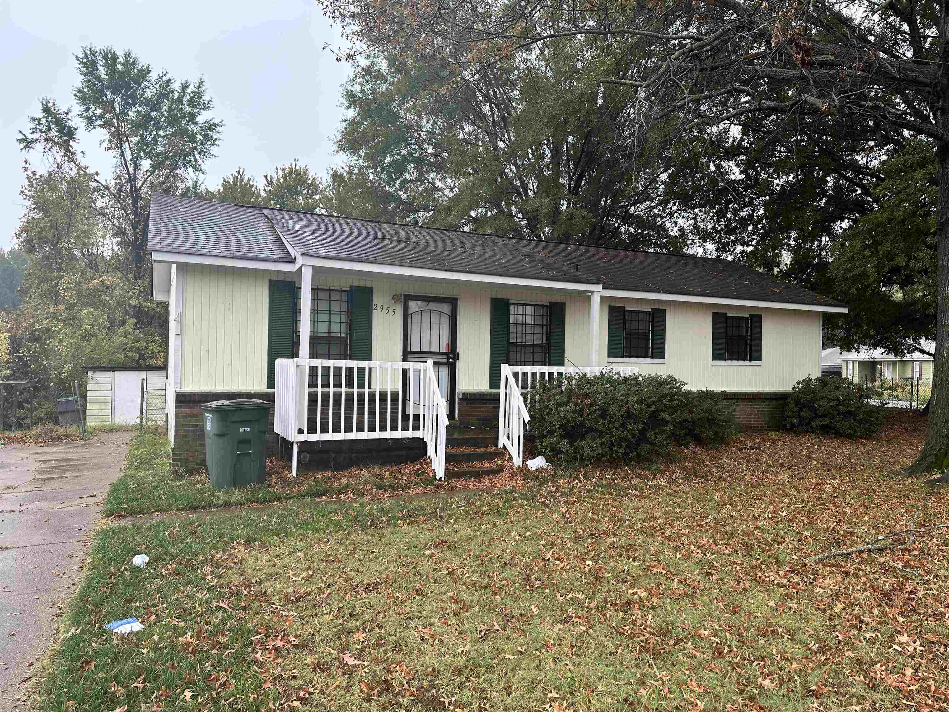 a view of a house with backyard and a tree