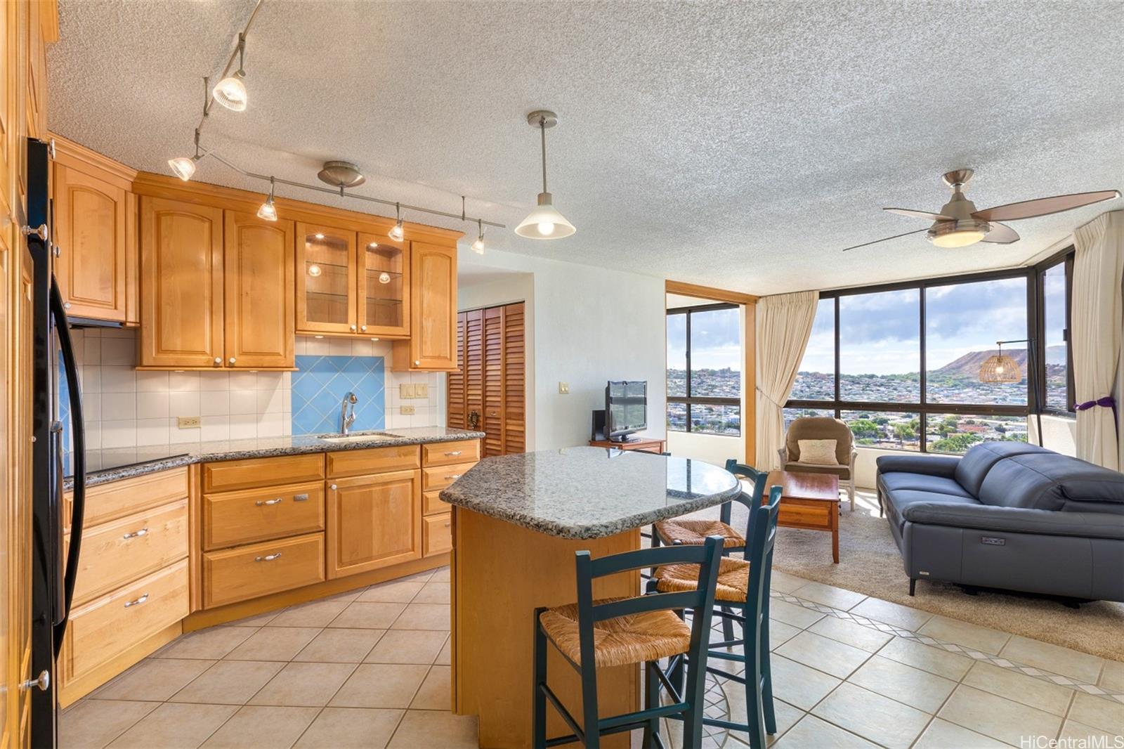 a large kitchen with kitchen island granite countertop a sink and a refrigerator