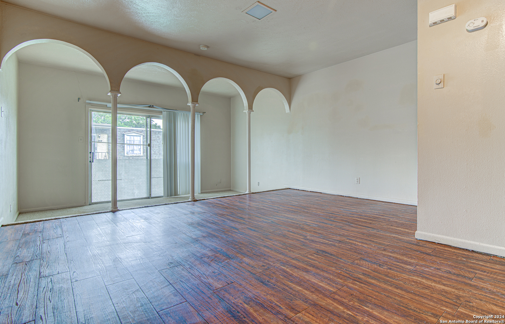 a view of empty room with wooden floor