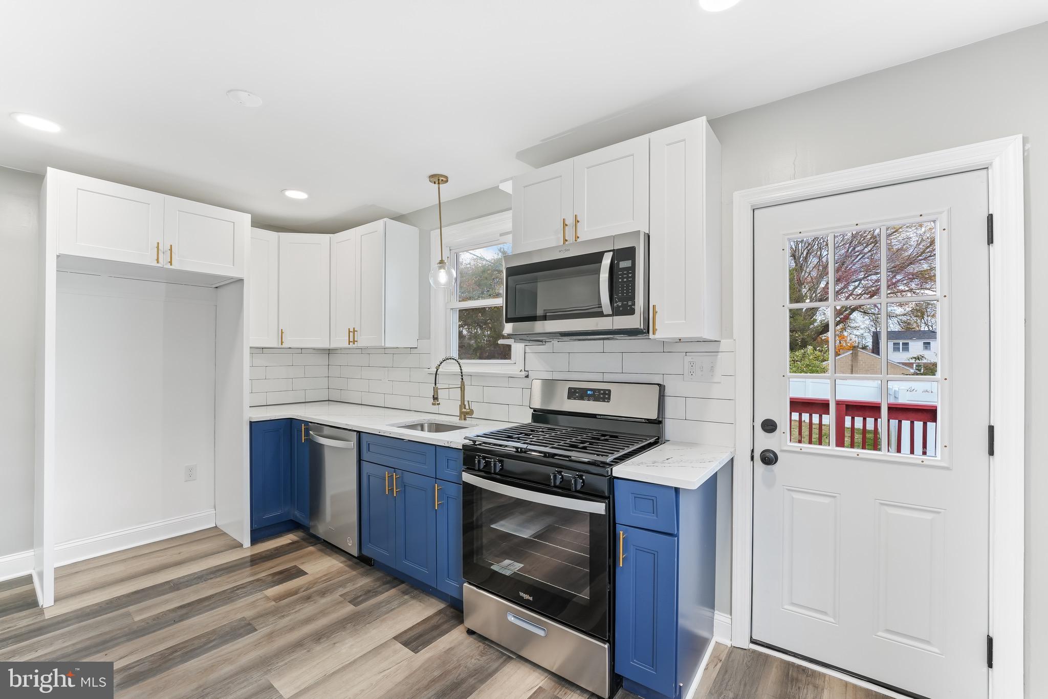 a kitchen with stainless steel appliances a stove microwave and sink