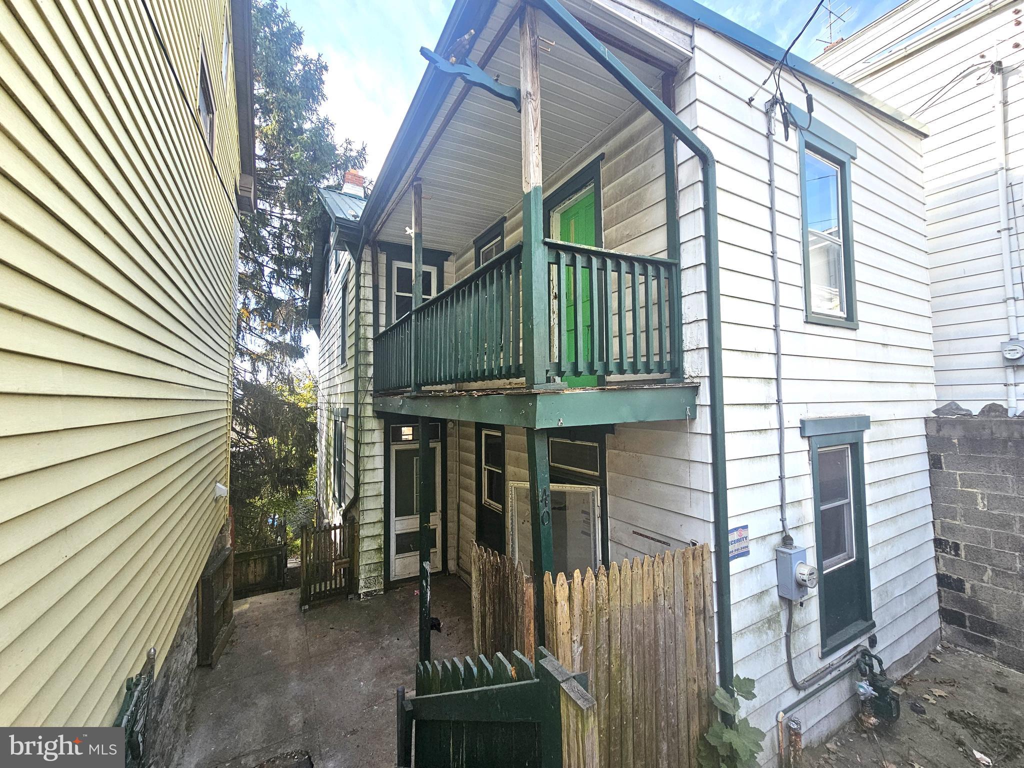 a view of a house with a small yard and wooden floor and fence