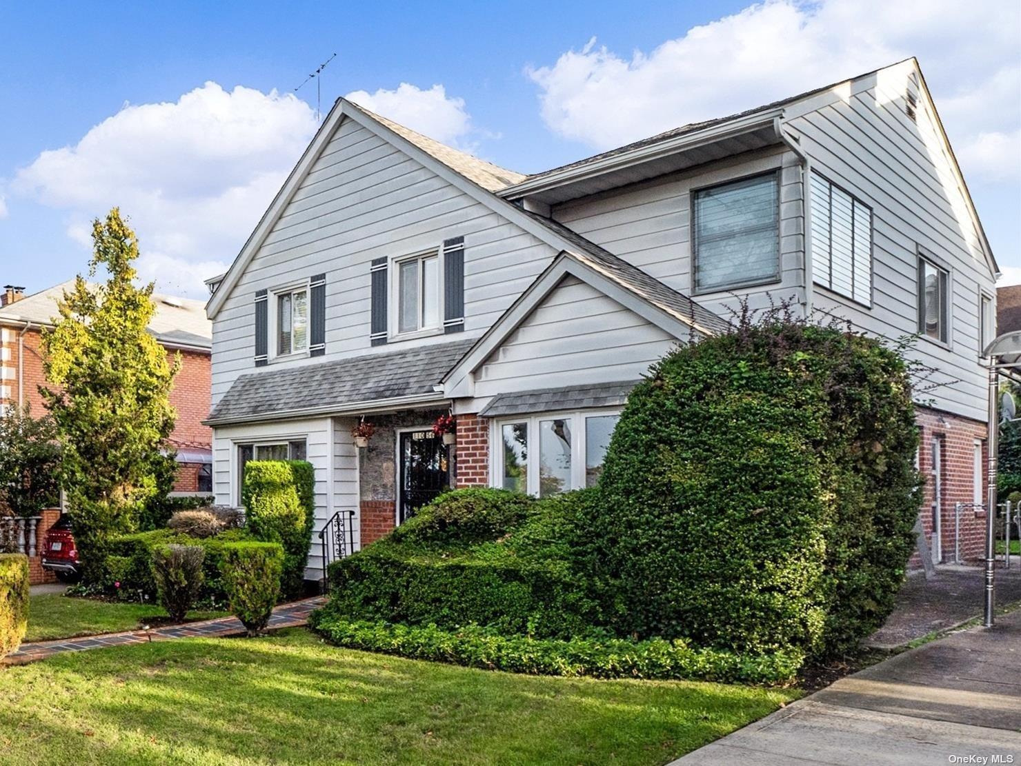 a front view of a house with a yard and potted plants