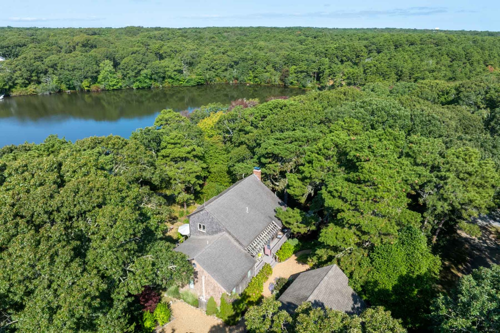 an aerial view of a house with a yard and lake view