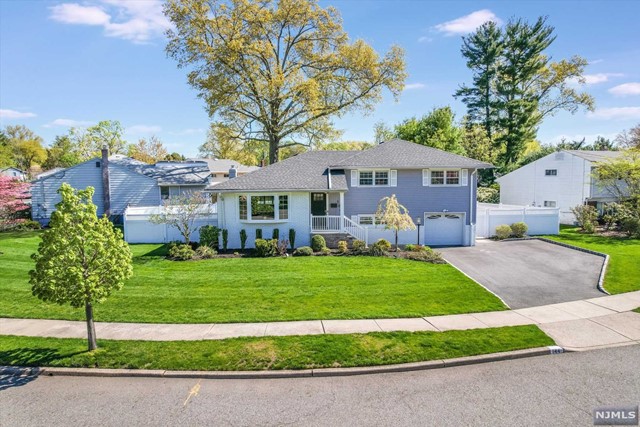 a front view of a house with a garden and trees