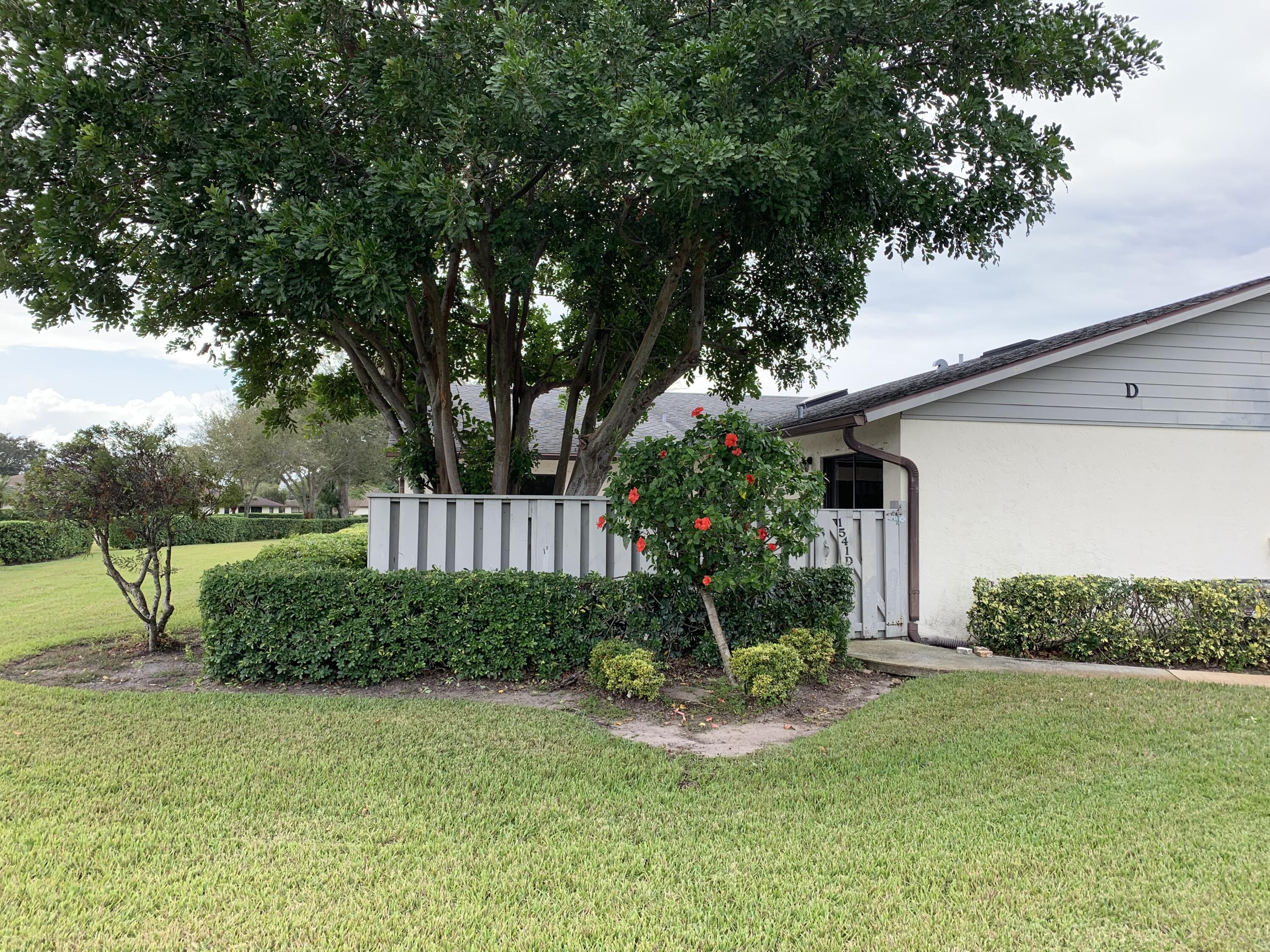 a view of a house with a yard and potted plants