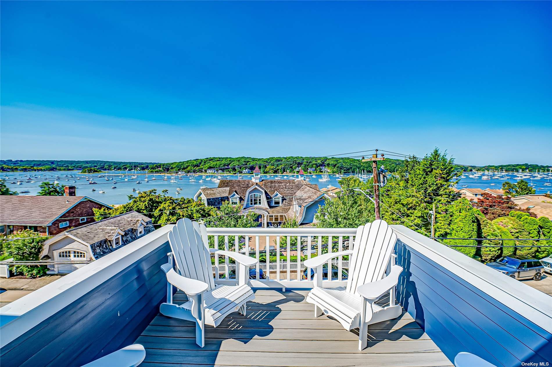 a view of a balcony with wooden chairs and ocean view