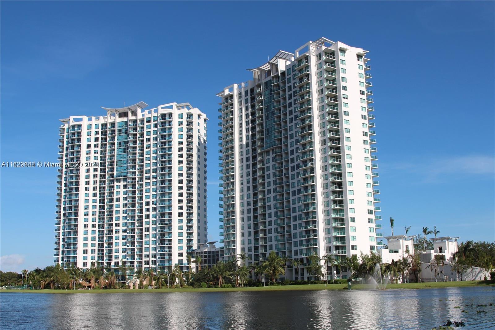 a view of a tall building next to a lake