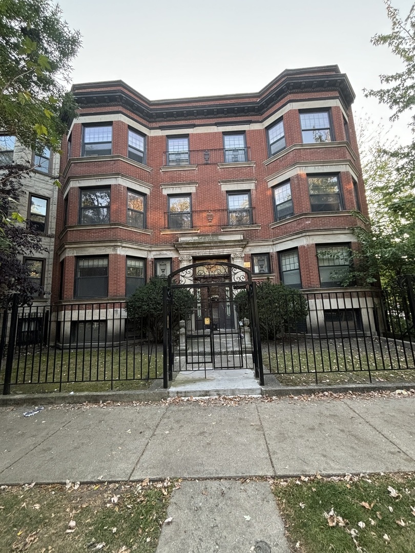 a front view of a residential apartment building with a yard