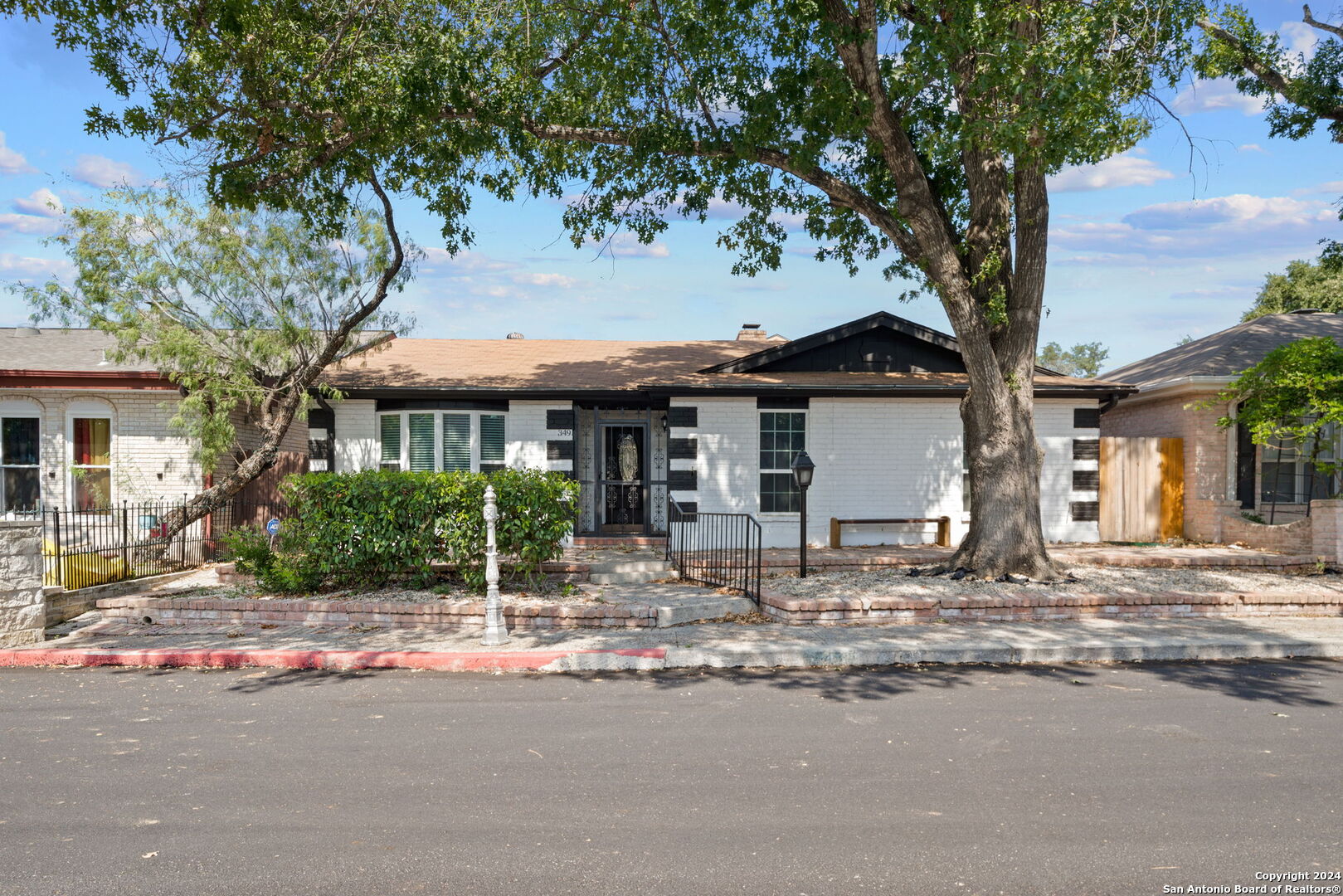 a front view of a house with yard and trees around