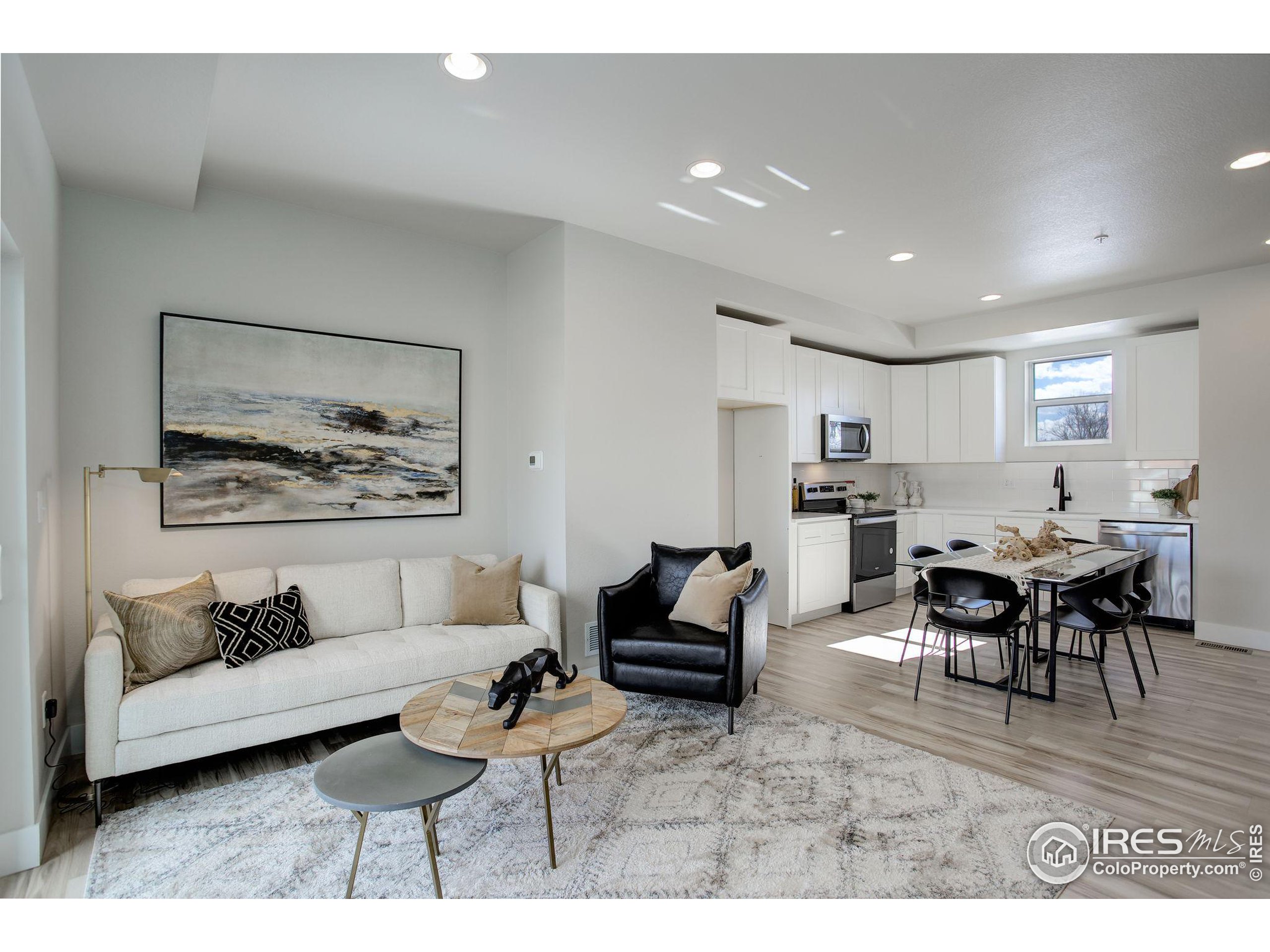 a living room with furniture and view of kitchen