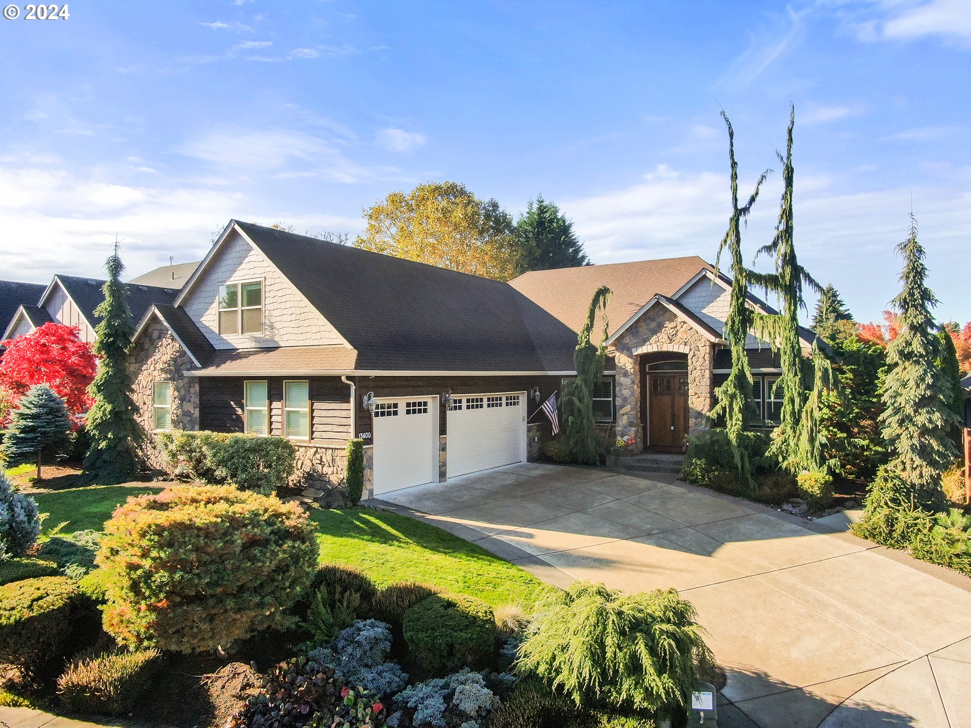 a front view of a house with a yard and a garden