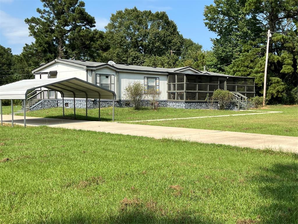 a view of a house with a yard and sitting area