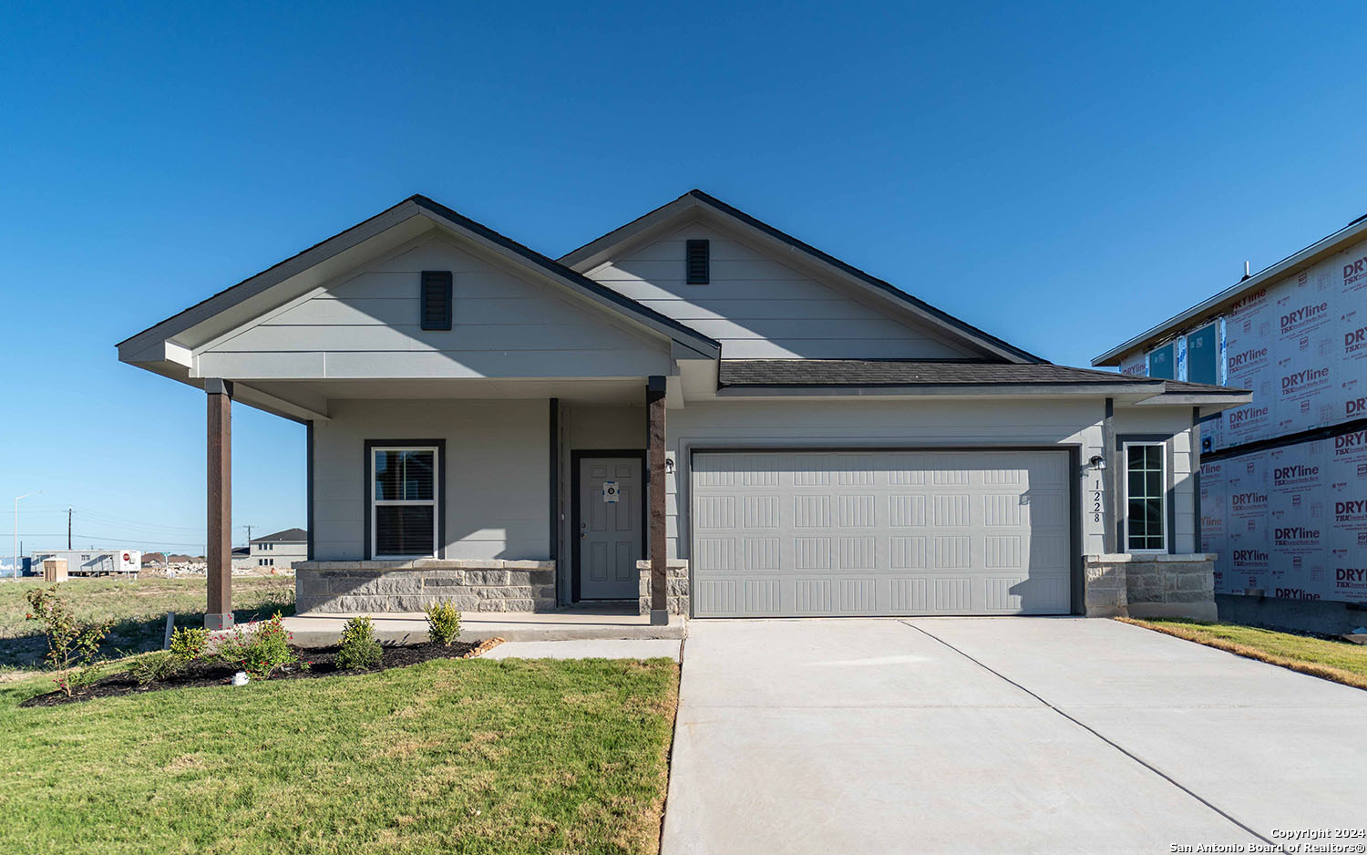 a front view of a house with a yard garage and outdoor seating