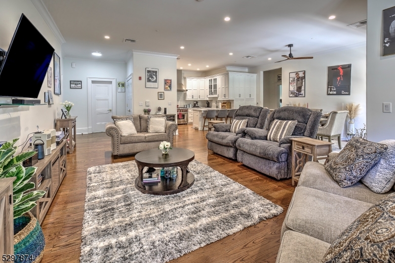 a living room with furniture a flat screen tv and kitchen view