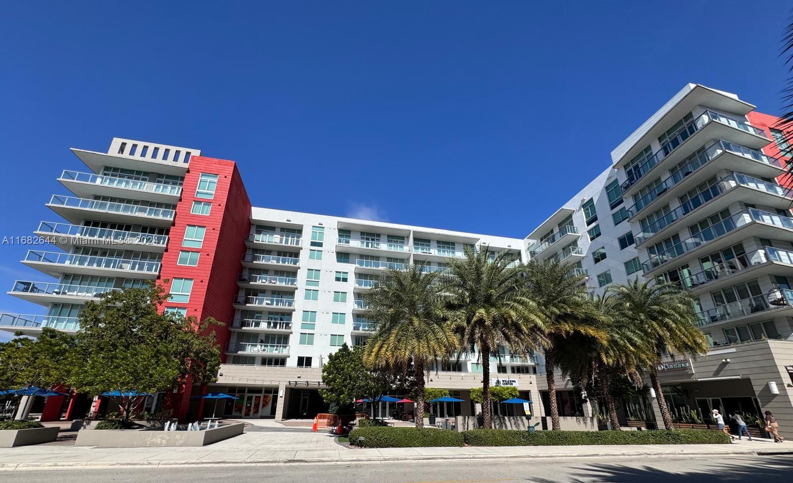 a front view of a building with a palm tree