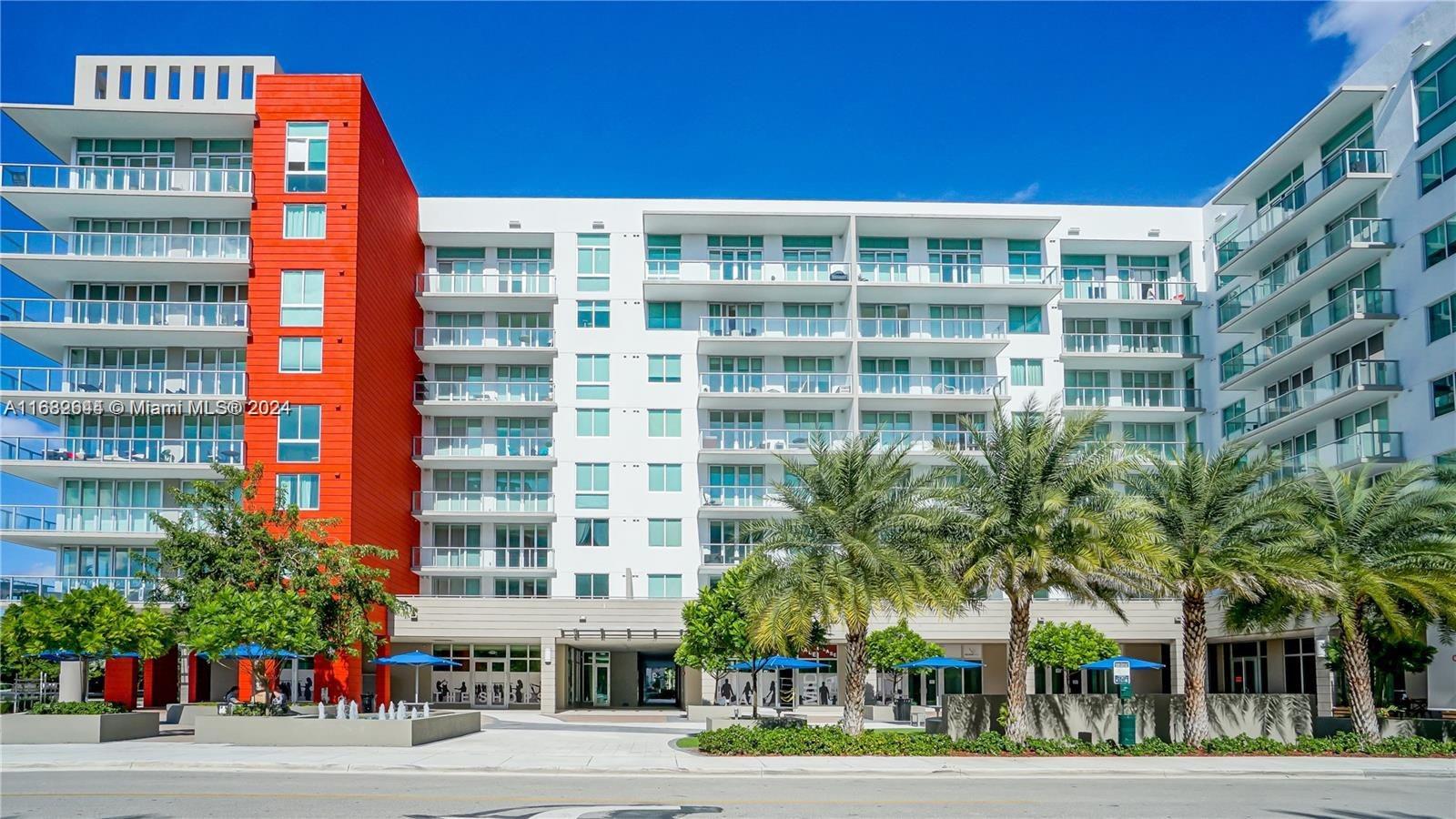 a front view of multi story residential apartment building with a yard