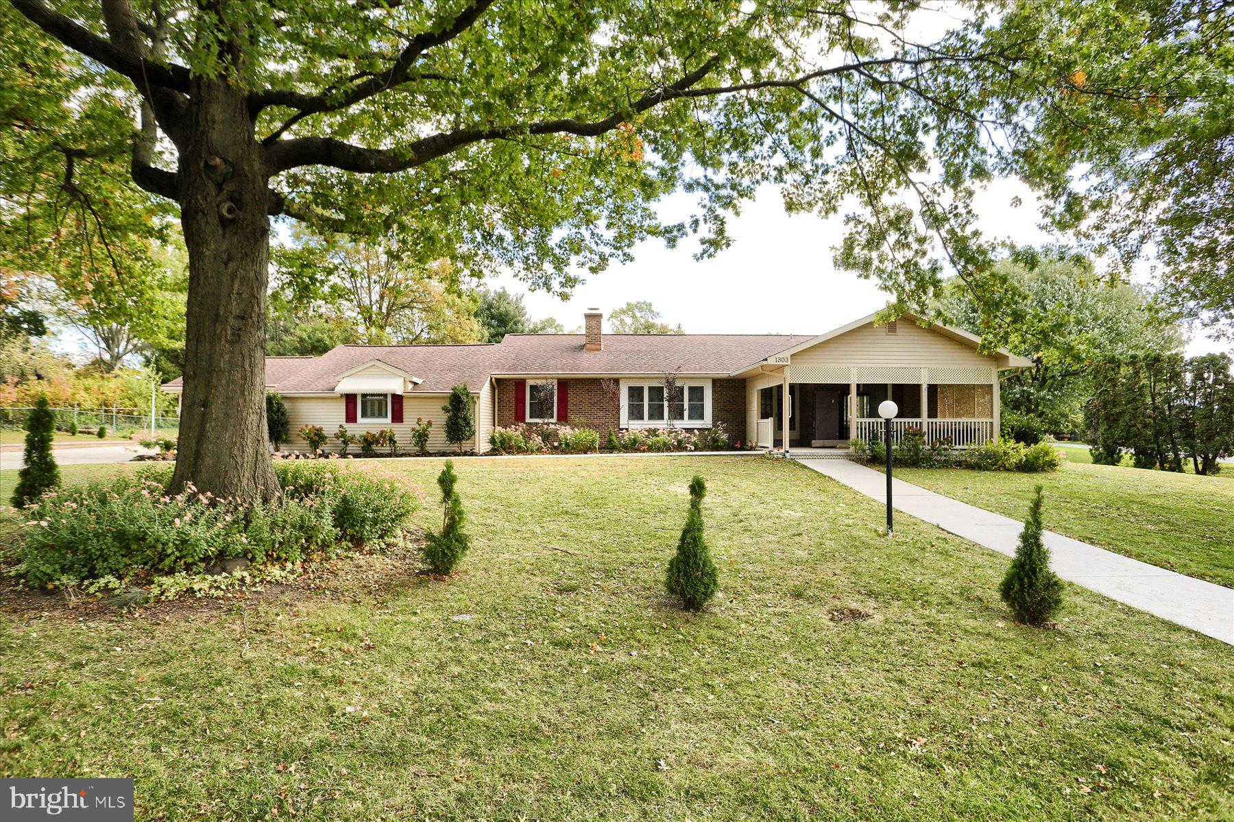 a front view of house with a garden and trees