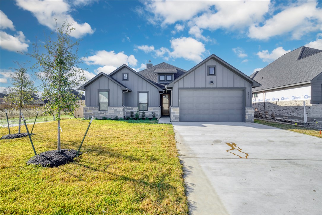 View of front of home with a garage and a front la