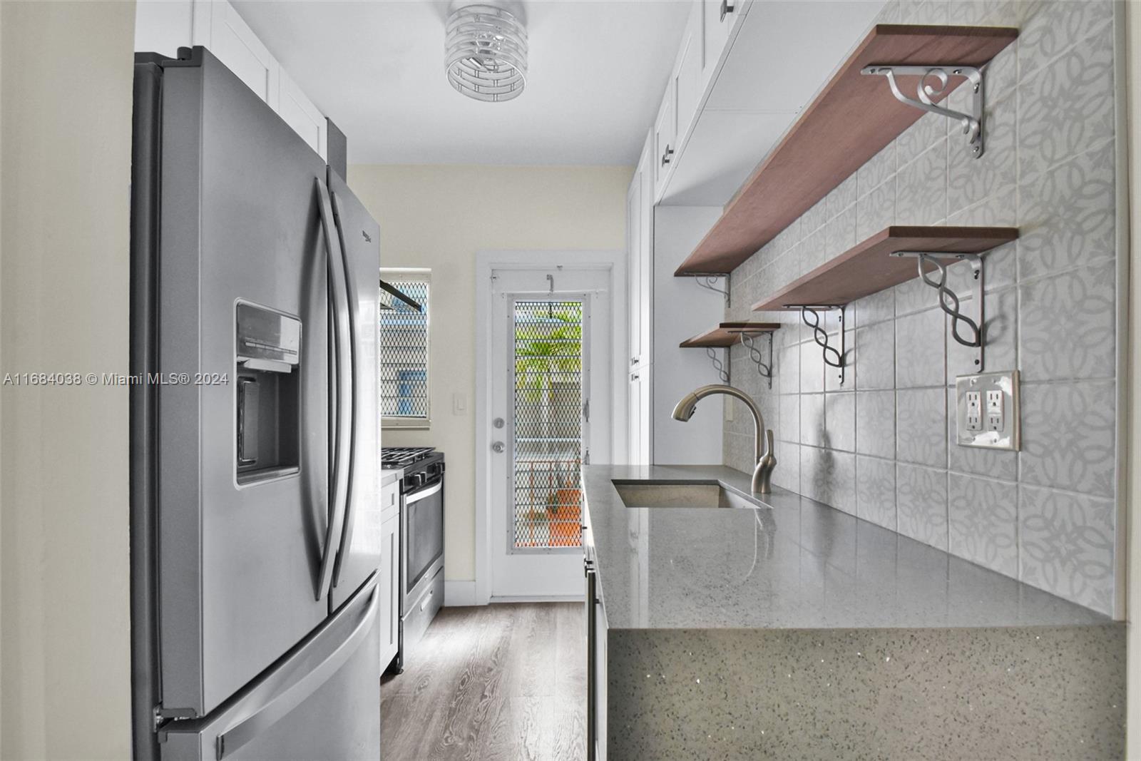 a view of a refrigerator a sink and cabinets