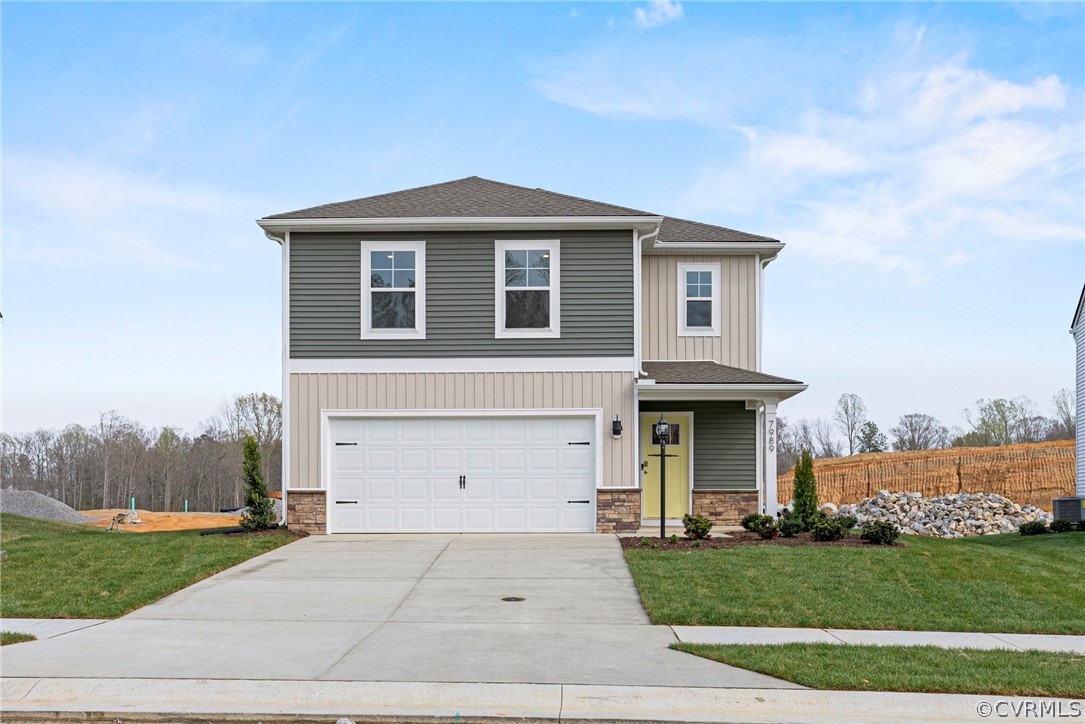 a front view of a house with a yard and garage