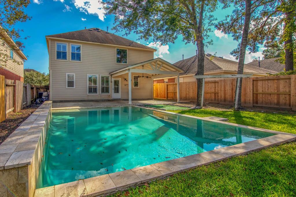 a view of a house with a yard patio and a small yard