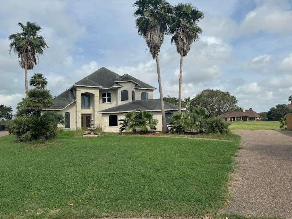 a front view of a house with garden and trees