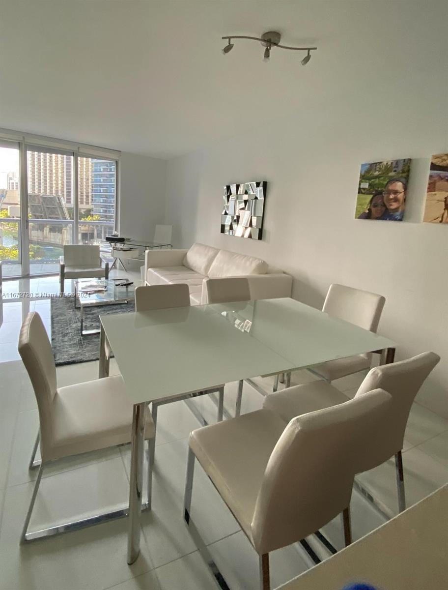 a dining room with furniture and a large window