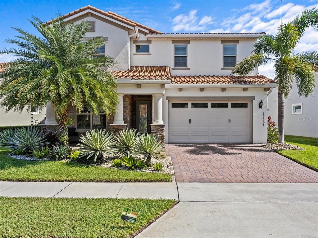 a front view of a house with a yard and a garage