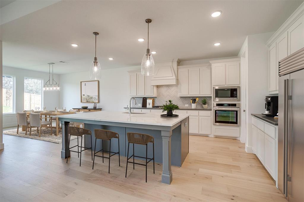 a kitchen with kitchen island granite countertop a sink counter and stainless steel appliances