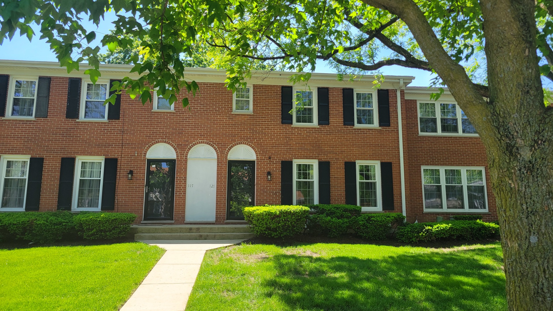 a front view of a house with yard and green space