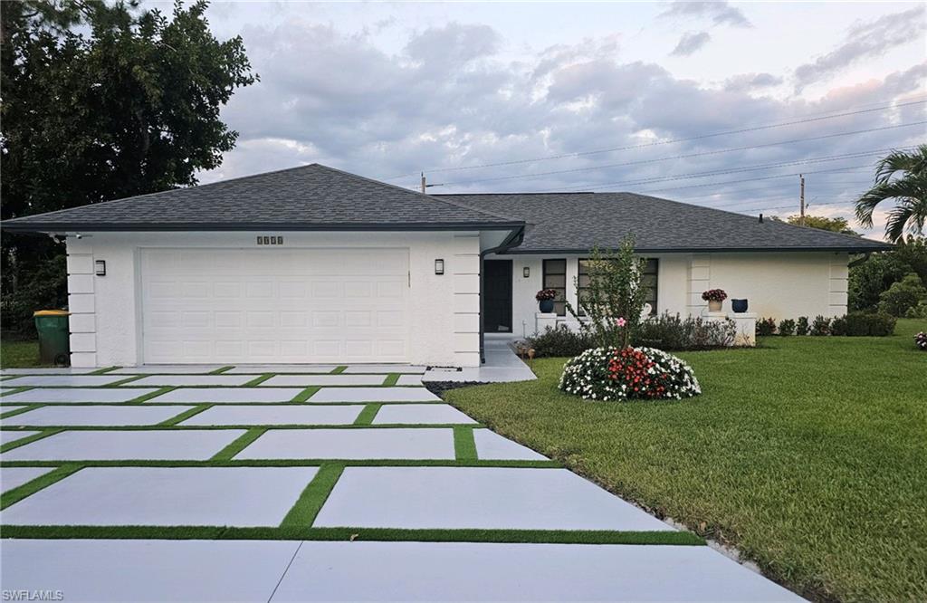 a front view of a house with a garden and trees