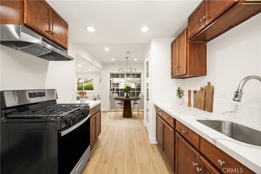 a kitchen with stainless steel appliances kitchen island granite countertop a large stove a sink dishwasher and a microwave oven with large wooden cabinets