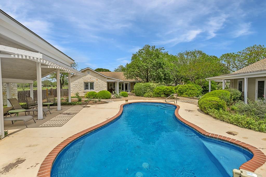 a view of a house with swimming pool and sitting area