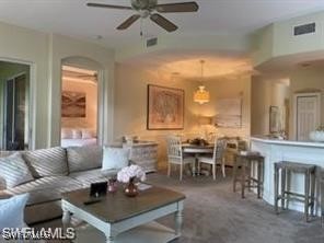 a living room with furniture a chandelier and a dining table