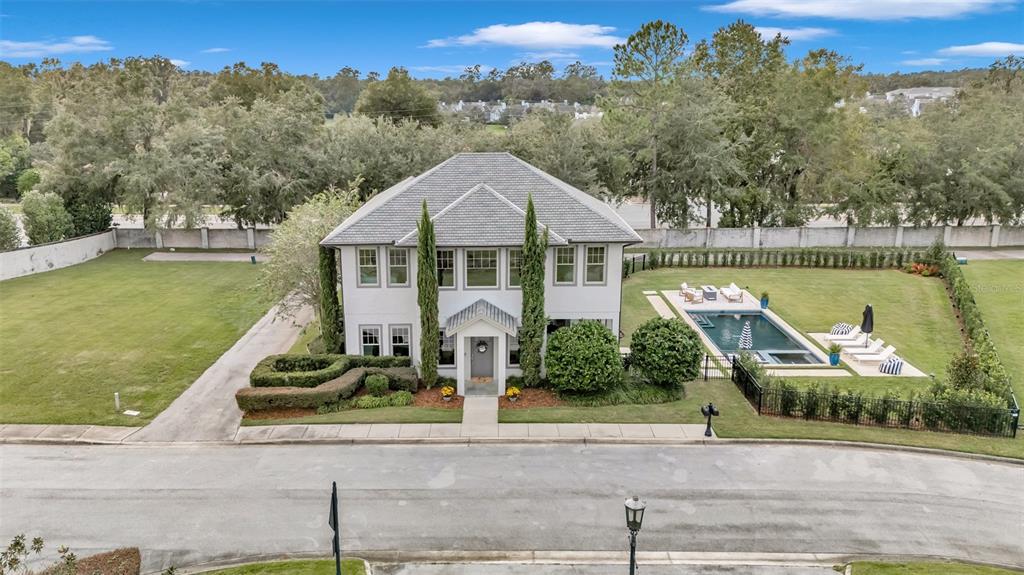 an aerial view of a house with a garden and lake view