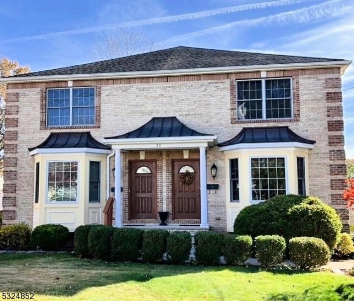 a front view of a house with yard and green space