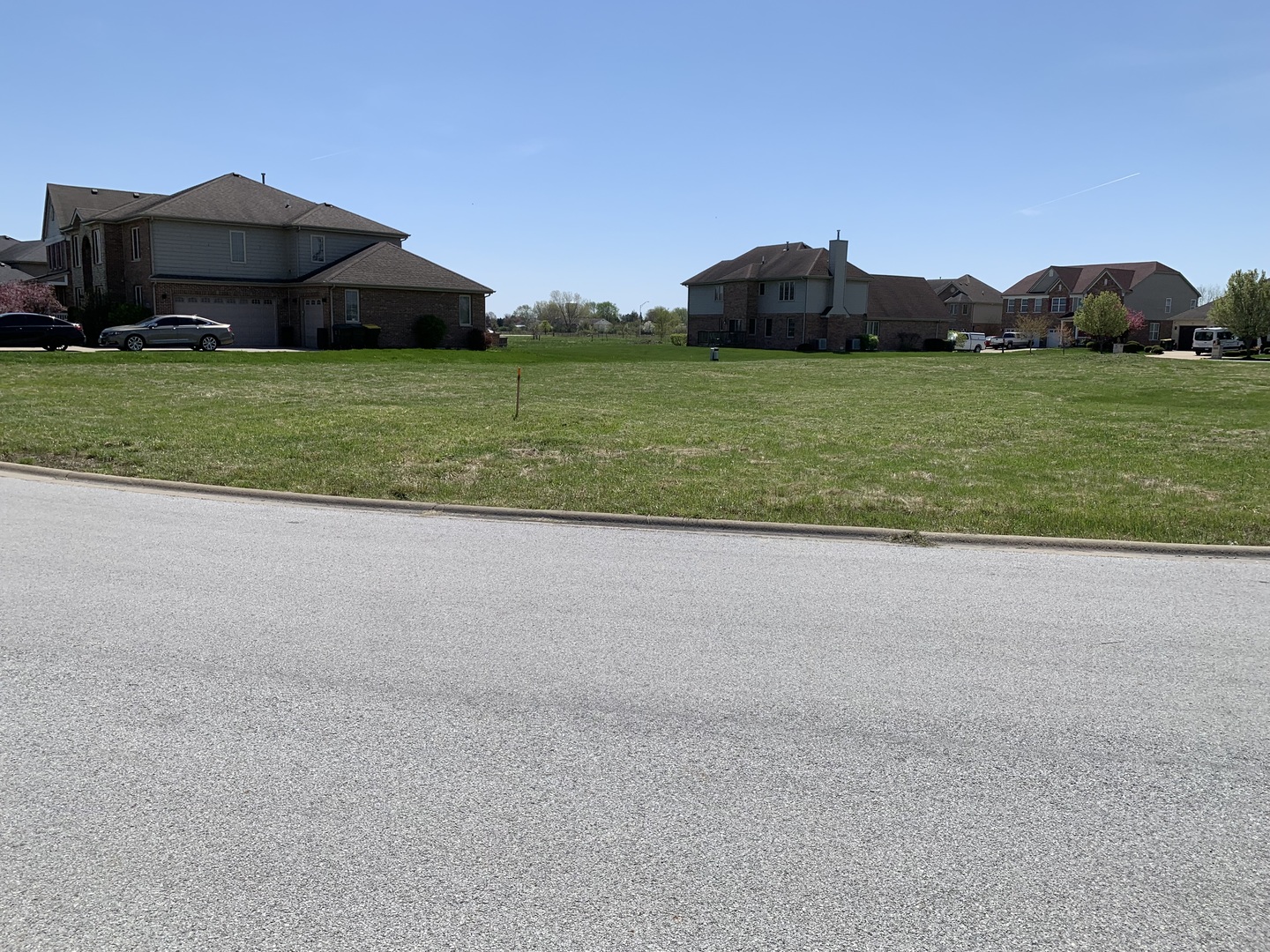 a view of a house with a yard and a large parking space