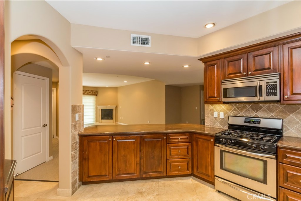 a kitchen with stainless steel appliances granite countertop a stove a sink and a refrigerator