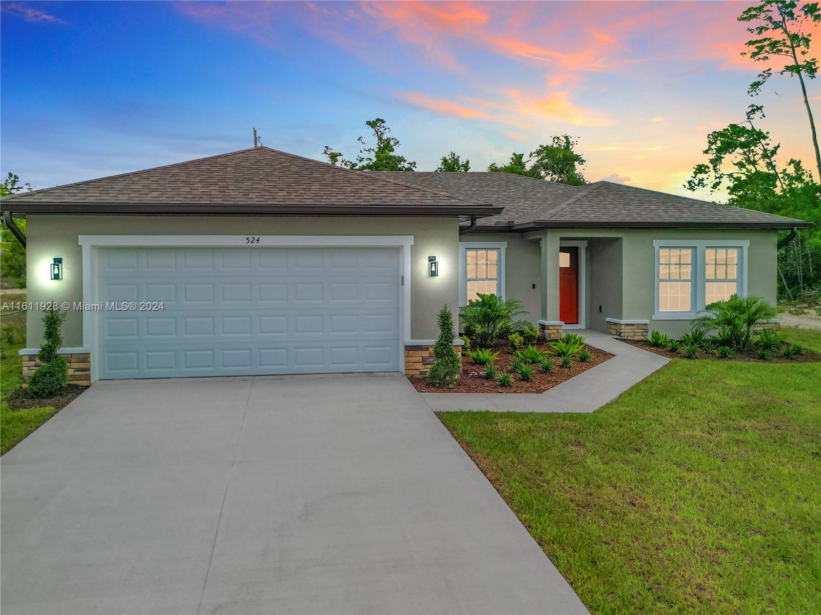 a front view of a house with a yard and garage