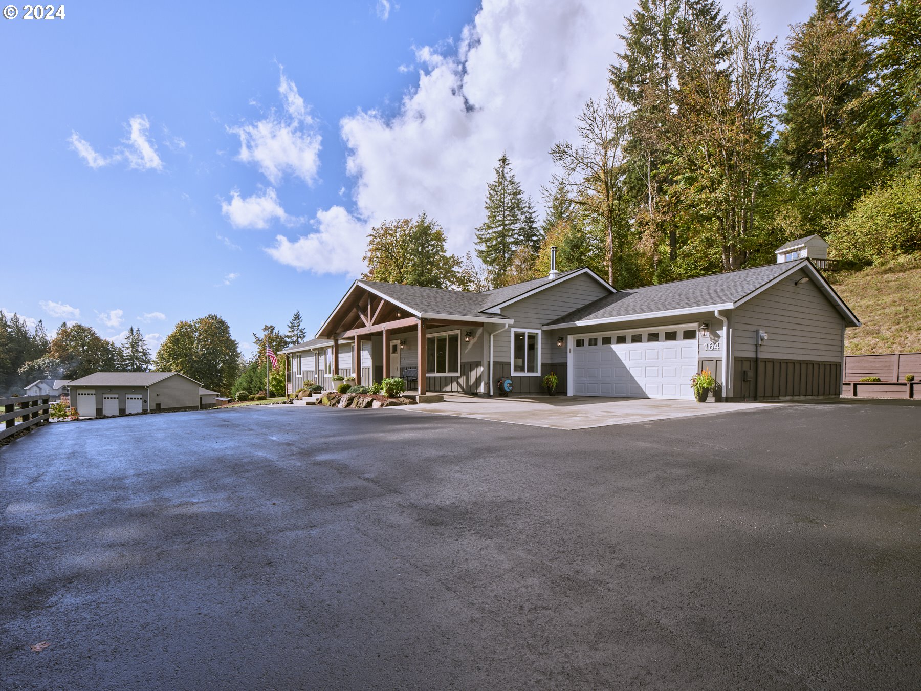 a front view of house with yard and trees in the background