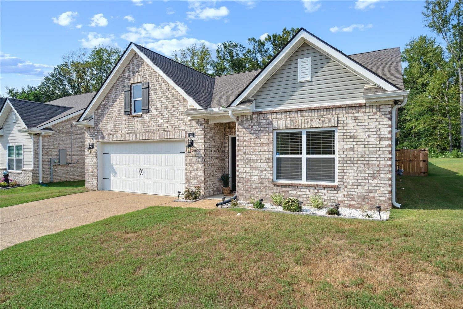 a front view of a house with a yard and garage