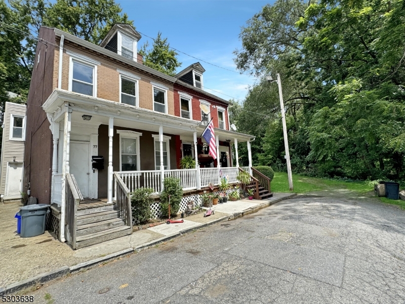 a view of a house with a yard and large tree