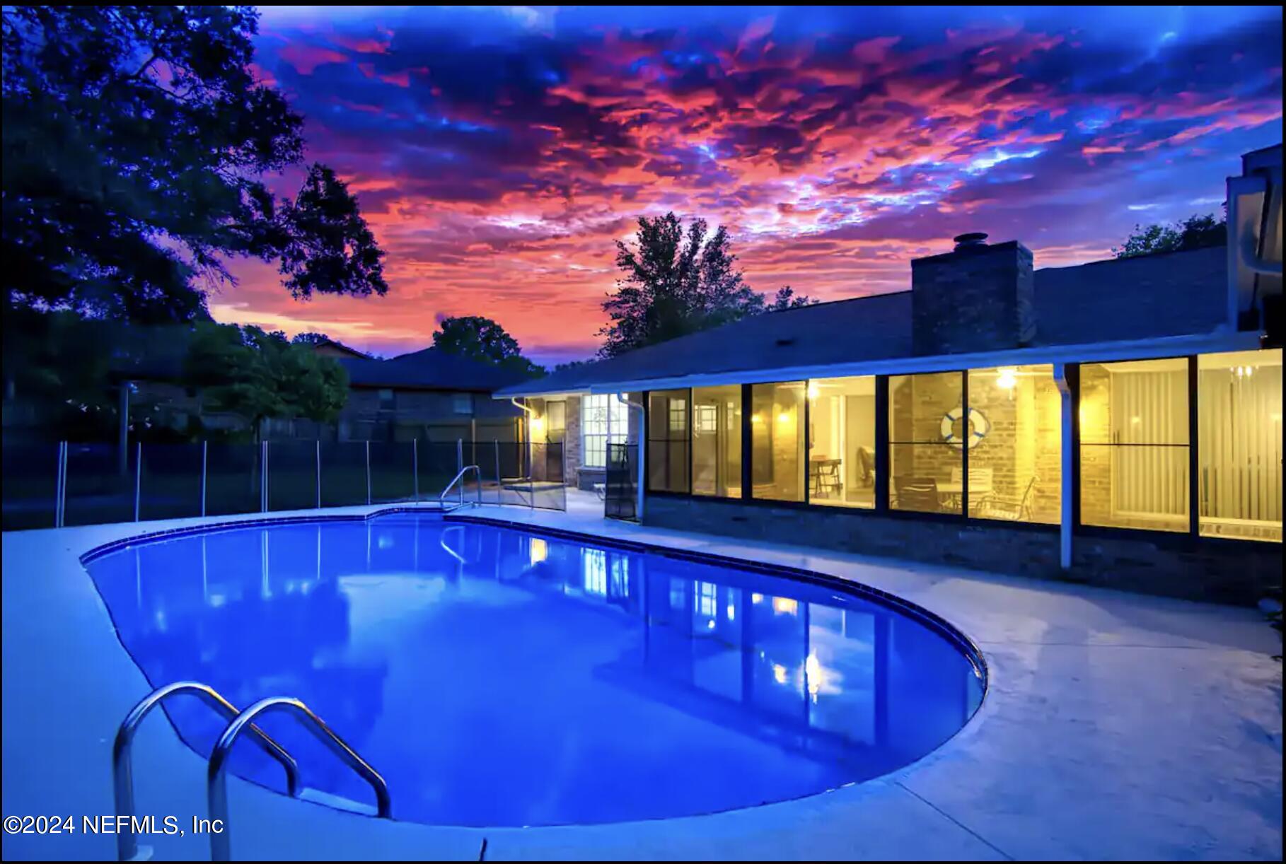 a view of swimming pool in a patio with a barbeque grill and a yard